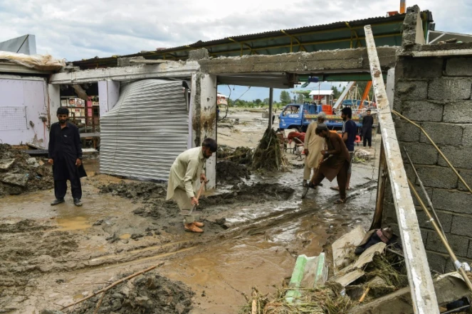 Des habitants tentent de dégager la boue qui a accompagné de violentes pluies de mousson, le 27 août 2022 à Mingora ( nord du Pakistan)