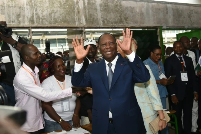 Le président ivoirien Alassane Ouattara salue la foule à son arrivée au bureau de vote, le 25 octobre 2015 à Abidjan, lors de l'élection présidentielle