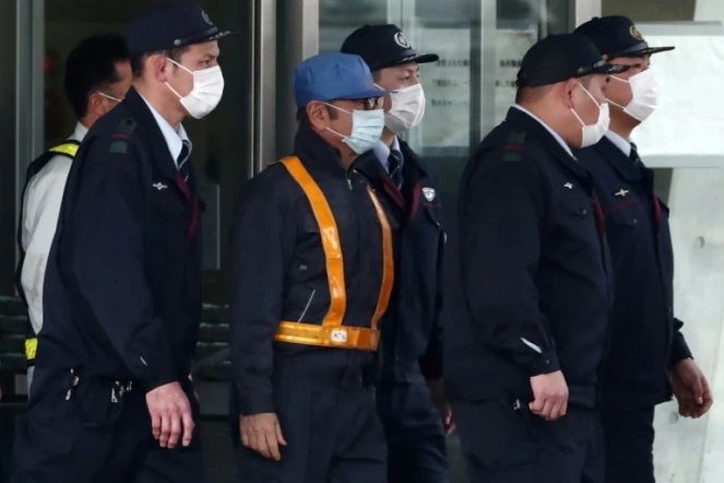 L'ancien patron de Renault Carlos Ghosn (c) est escorté à sa sortie de détention suite au versement d'une caution, à Tokyo, le 6 mars 2019