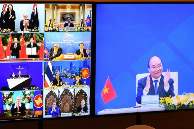 Le Premier ministre vietnamien Nguyen Xuan Phuc (d) applaudit l'accord signé par 15 pays de l'Asean, le 15 novembre 2020, à HanoÏ
