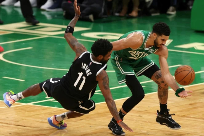 Jayson Tatum (d.) des Boston Celtics et Kyrie Irving (g.) des Brooklyn Nets se dispiutent la balle pendant le quatrième quart-temps du deuxième match du premier tour des play-offs de la Conférence Est au TD Garden, le 20 avril 2022, à Boston (Massachusetts)