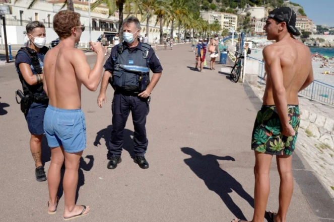Des policiers patrouillent le long de la promenade des Anglais à Nice le 3 août 2020 pour informer les passants du port du masque obligatoire