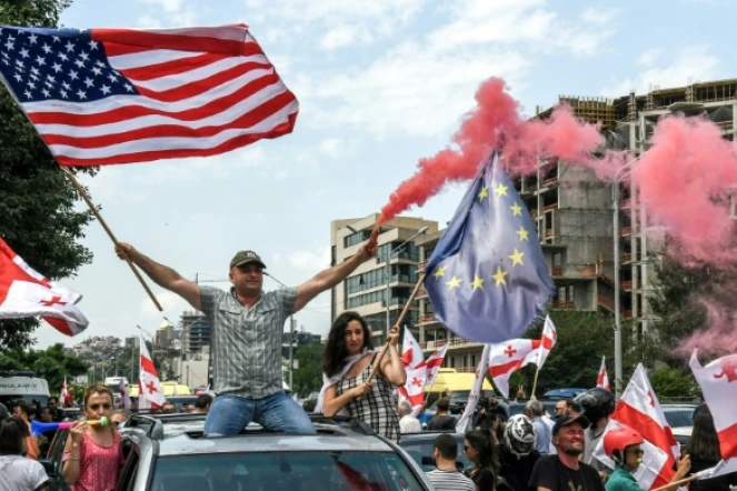 Des manifestants géorgiens brandissent des drapeaux américain et européen lors à Tbilissi le 24 juin 2019
