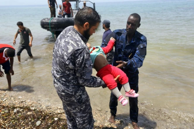 Des membres de la sécurité libyenne portent le corps d'un bébé dans la ville d'al-Hmidiya, après le naufrage au large de la Libye d'une embarcation de migrants dont 100 sont toujours portés disparus, le 29 juin 2018 