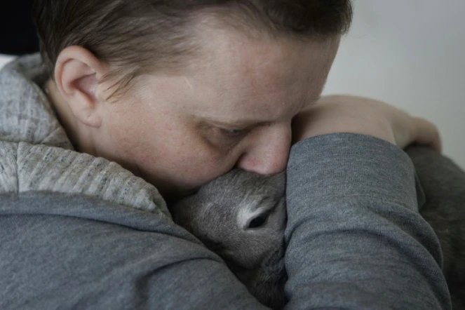 Lydie Imhoff serre dans ses bras sa lapine Lucky, dans son appartement vide à Besançon, à la veille de son départ pour une euthanasie en Belgique, le 30 janvier 2024