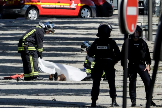 Des policiers recouvrent le corps d'un assaillant, après un attentat avorté sur les Champs-Élysées, le 19 juin 2017 à Paris