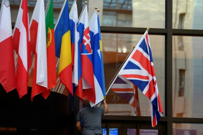Un employé installe le drapeau britannique à l'entrée du Conseil européen à Bruxelles, le 28 octobre 2019
