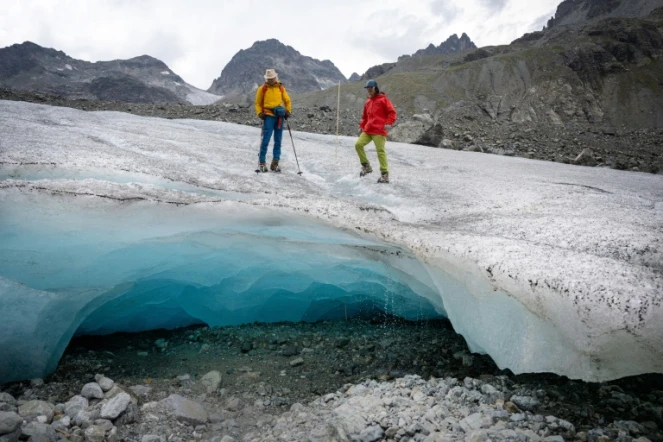 Les glaciologues Andrea Fischer (G) et Violeta Lauria, de l'Académie autrichienne des sciences, marchent sur le glacier Jamtal près de Galtür, en Autriche, le 20 juillet 2022