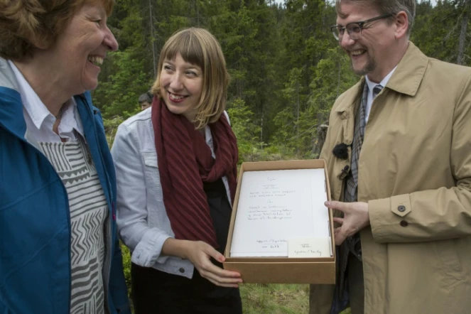 L'artiste écossaise Katie Paterson (c), la mair d'Oslo Marianne Borgen et l'auteur Sjon avec son manuscrit pour la bibliothèque du futur, dans une forêt près d'Oslo, le 2 juin 2017