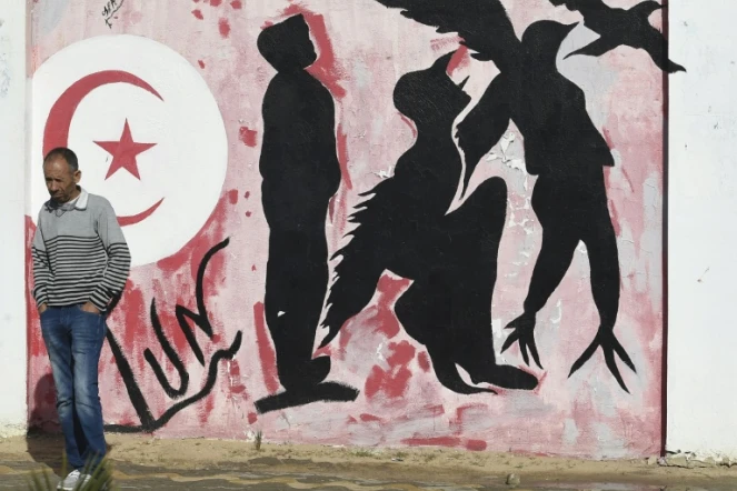 Un homme devant un graffiti que la place Mohamed Bouazizi, dans le centre de Sidi Bouzid, le 27 octobre 2020