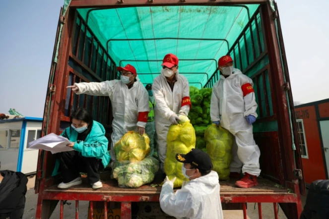 Des employés distribuent des stocks de nourriture le 5 mars 2020 dans la ville de Wuhan