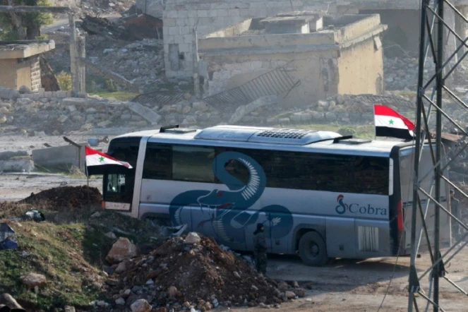 Un bus au passage de Ramoussa, sous contrôle des forces gouvernementales syriennes dans le sud d'Alep, le 18 décembre 2016 dans le cadre d'une opération d'évacuation de civils et de soldats rebelles  