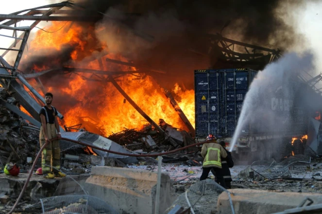 Des pompiers luttent contre un incendie après deux puissantes explosions à Beyrouth, le 4 août 2020
