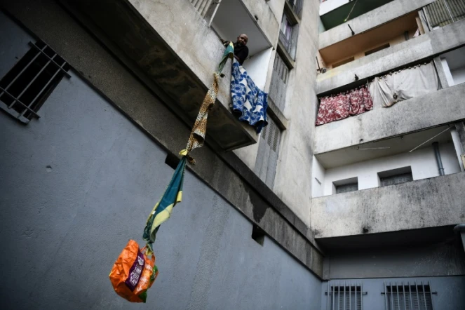 Un habitant souffrant du quartier Maison Blanche (Marseille) hisse chez lui  de la nourriture offerte par ses voisins, le 31 mars 2020 