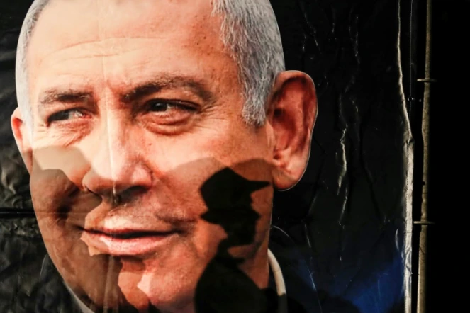 L'ombre d'un passant se projette sur un portrait du Premier ministre israélien Benjamin Netanyahu, à Jérusalem, le 11 décembre 2019