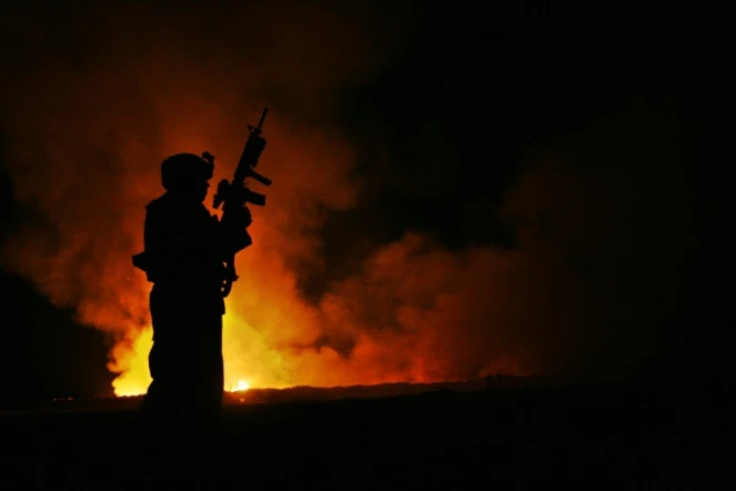 Un Marine veille sur un "burn pit" du camp Falloujah des forces armées américaines en Irak, le 11 juin 2007