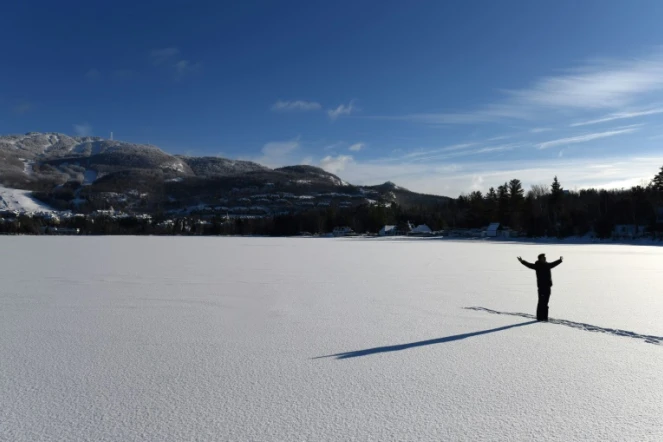 Un homme pose pour une photo sur le lac Tremblant dans la région des Laurentides au Québec, Canada, au pied du Mont Tremblant le 24 décembre 2017