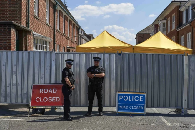 Des policiers en faction le 8 juillet 2018 devant un foyer de sans-abri où vivait Dawn Sturgess à Salisbury dans le sud-ouest de l'Angleterre
