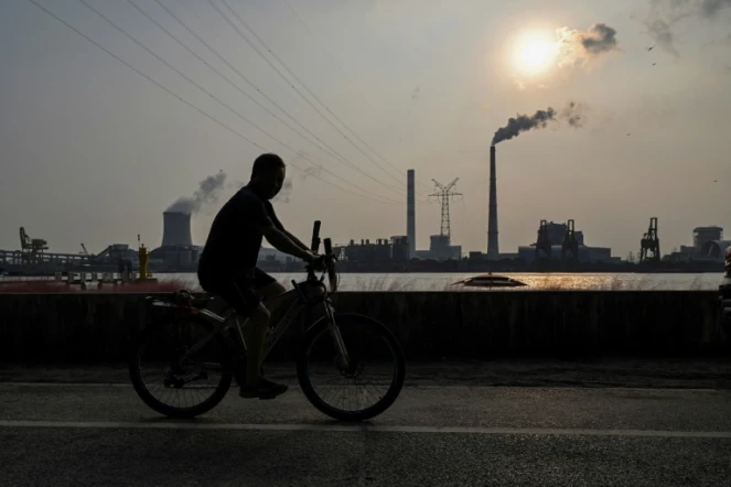 Promenade à vélo en Chine le long du fleuve Huangpu, près de la centrale électrique au charbon de Wujing, à Shangaï, le 28 septembre 2021 