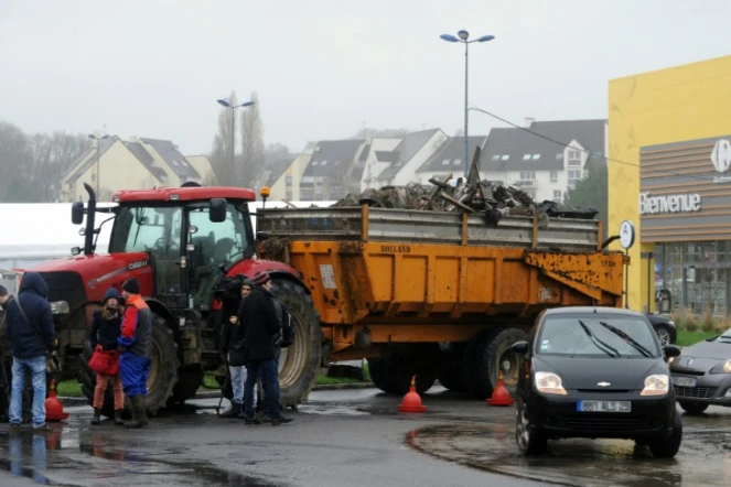 Des agriculteurs français bloquent l'accès à un hypermarché avec leurs tracteurs et leurs remorques chargées de déchets à Quimper, le 2 février 2016