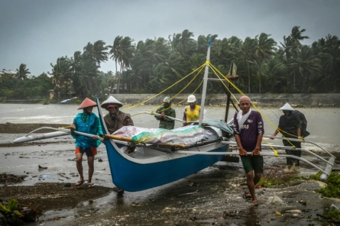Des pêcheurs mettent un bateau à l'abri avant l'arrivée du typhon Phanfone, à Baybay (Philippines) le 24 décembre 2019