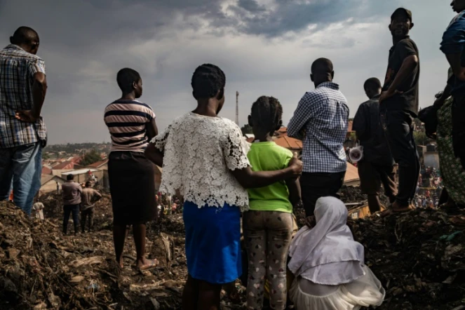 Des habitants assistent aux recherches des secours après l'effondrement d'une décharge à Kampala, le 10 août 2024 