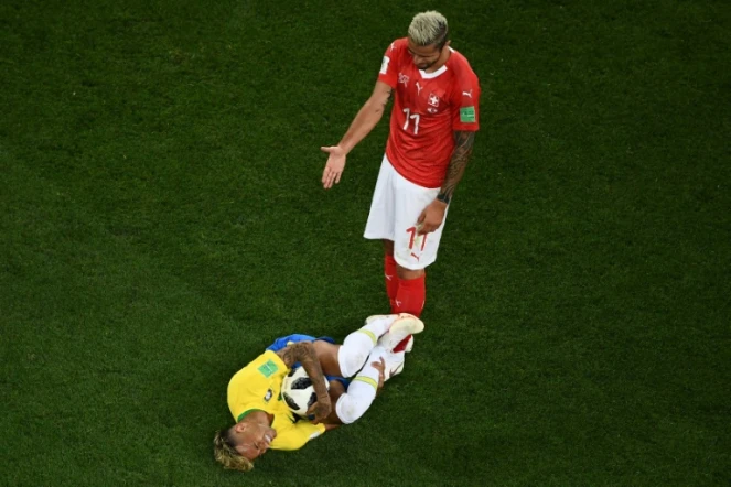Le Brésilien Neymar au sol sous les yeux du Suisse Valon Behrami, agacé, lors du Mondial, le 17 juin 2018 à Rostov