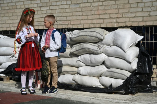 Des écoliers ukrainiens font leur rentrée devant des sacs de sable protégeant leur école, à Lviv en Ukraine le 1er septembre 2023