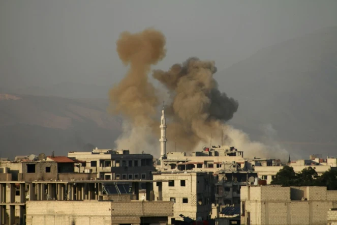 De la fumée s'élève après un bombardement du régime au-dessus de la ville sous contrôle rebelle de Saqba, dans la Ghouta orientale, près de Damas, le 11 mars 2018
