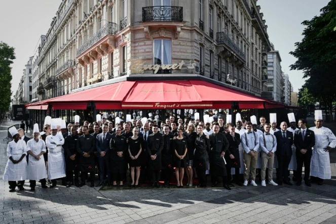 Les employés du restaurant Le Fouquet's sur les Champs Elysés à Paris posent le 13 juillet 2019 devant la brasserie à la veille de sa réouverture