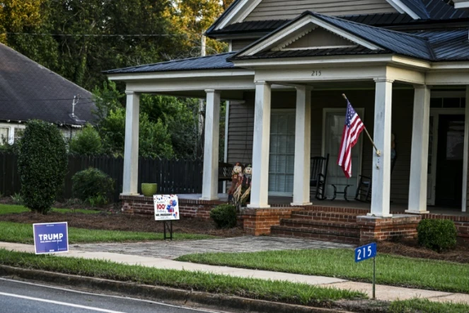 Une pancarte pro-Trump et une autre marquant le centième anninversaire de l'ancien président américain Jimmy Carter devant une maison de Plains (Géorgie, sud-est), le 30 septembre 2024