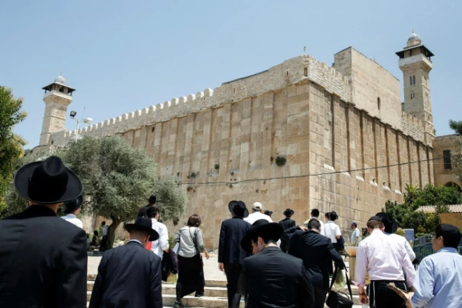 Des religieux juifs et des touristes marchent vers le Tombeau des Patriarches, également appelé Mosquée d'Ibrahim, à Hebron, le 7 juillet