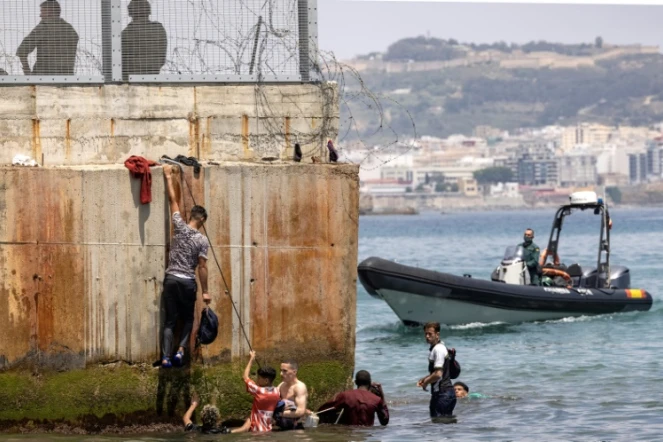 Des policiers espagnoles tentent de disperser des migrants qui arrivent à l'enclave espagnole de Ceuta, le 18 mai 2021 à Fnideq