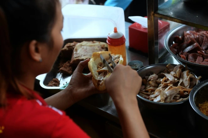 Préparaion d'un sandwich appelé banh-mi à Hanoï, le 31 août 2016