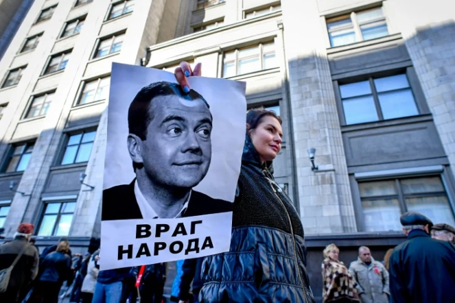 Un manifestant brandit une photo du Premier ministre russe Dmitri Medvedev sous laquelle on peut lire "Ennemi du peuple" au cours d'un rassemblement contre la réforme des retraites, à Moscou le 26 septembre 2018.