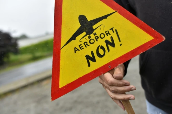 Un opposant à la construction d'un aéroport à  Notre-Dame-des-Landes tient une pancarte pour appeler à voter non à ce projet, le 13 juin 2016 à Notre-Dame-des-Landes 