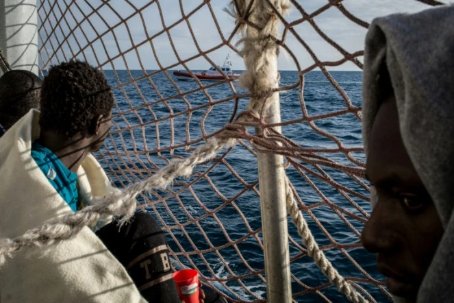 Des migrants à bord du Sea Watch 3 observent un bateau des garde-côtes italiens
