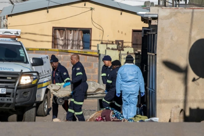 Les secours évacuent les corps des victimes d'une fusillade dans un bar de Soweto, à Johannesburg, le 10 juillet 2022
