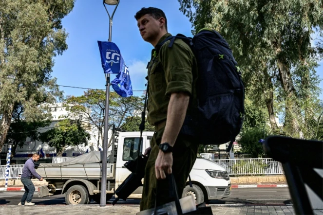 Un soldat israélien avec tout son barda dans une rue de Nahariya, dans le nord d'Israël, le 3 janvier 2024
