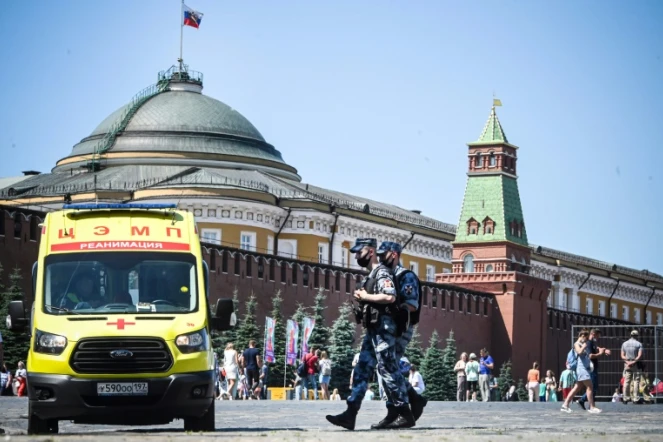 Des soldats de la garde nationale russe en patrouille sur la place Rouge où est stationnée une ambulance, le 18 juin 2021 à Moscou