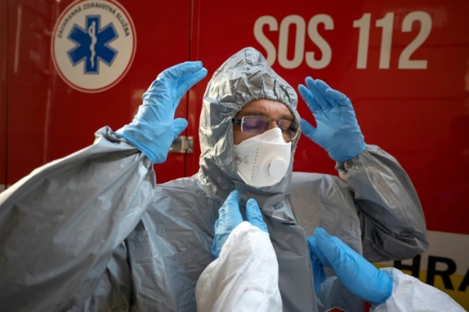 Un membre du personnel soignant revêt sa tenue de protection avant de s'occuper de malades, à Bratislava, en Slovaquie, le 16 mars 2020