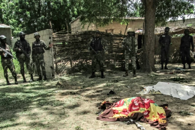 Des membres de la sécurité camerounaise devant la dépouille d'une victime d'un attentat suicide à Kolofata, dans l'extrême nord du Cameroun, le 13 septembre 2015