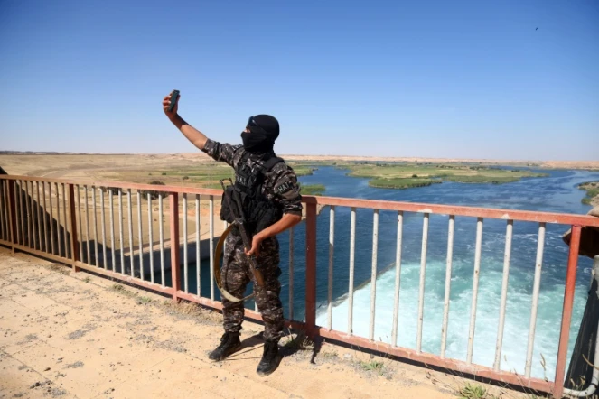 Un membre des forces se photographie devant le barrage de Tabqa en Syrie le 12 mai 2017