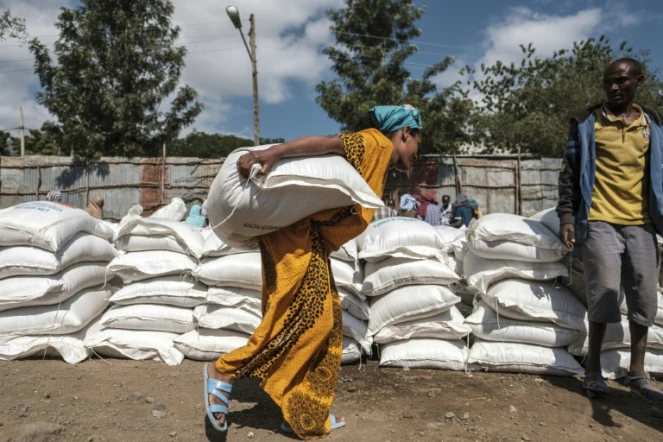 Une femme récupère un sac de blé lors d'une distribution d'aide alimentaire du gouvernement éthiopien à Alamata le 11 décembre 2020