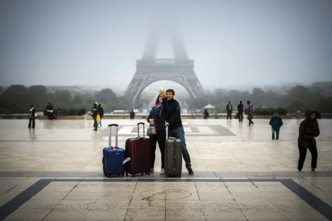 Des touristes font un selfie devant la tour Eiffel à Paris, le 26 octobre 2016