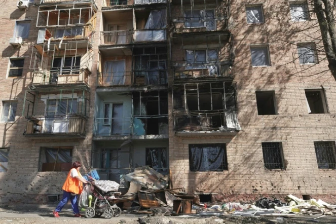 Une habitante passe devant un immeuble touché par des frappes ukrainiennes à Koursk, le 16 août 2024 en Russie