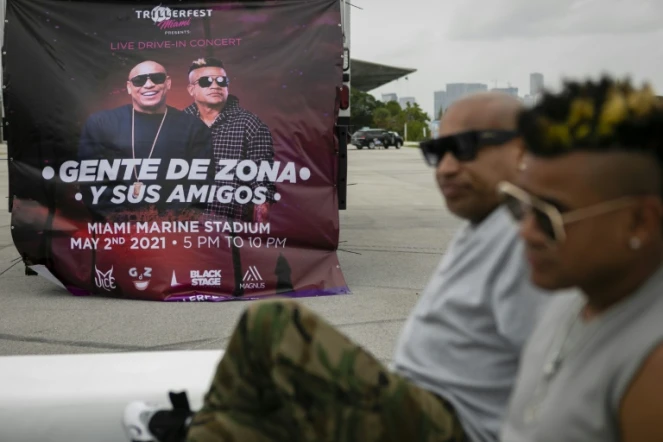 Une affiche du concert de Gente de Zona, derrière les membres du groupe Alexander Delgado et Randy Malcom à Key Biscayne, en Floride, le 20 avril 2021