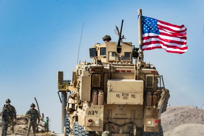 Un véhicule militaire américain lors d'une manifestation de Kurdes près de Ras al-Aïn aux abords de la frontière turque, le 6 octobre 2019