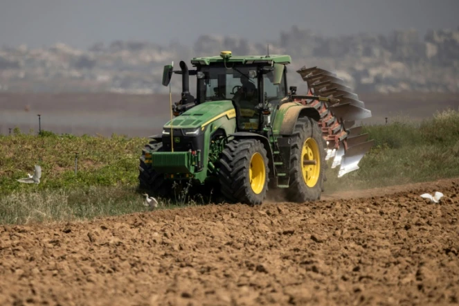 Un agriculteur en tracteur dans un champ agricole près de la frontière entre le sud d'Israël et la bande de Gaza, le 21 mai 2025