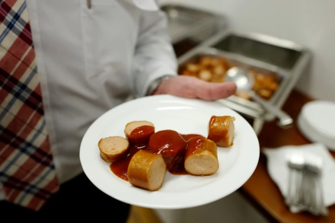 Un employé du constructeur automobile allemand Volkswagen tente une assiette de currywurst (saucisse au curry), au siège de l'entreprise à Wolfsburg en Allemagne le 21 avril 2016